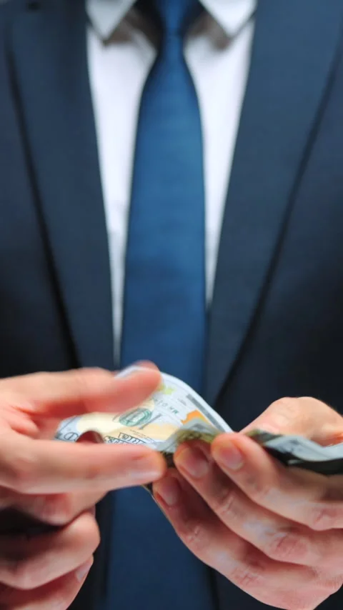 Formally dressed man is counting US Dollar bills, close-up. Video stock 340407764