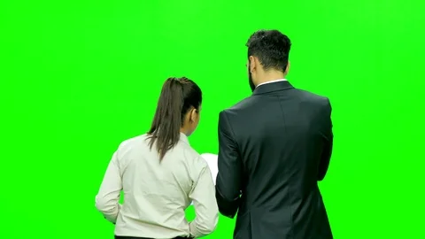 Formally dressed young boy and girl with file discussing against the green Video stock 116022227