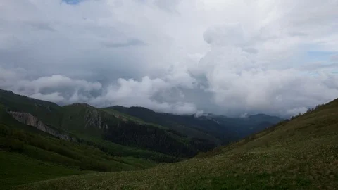 The formation and movement of clouds over the summer slopes of Bolshoy Thach Stock Footage 83493343