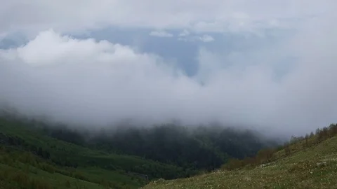 The formation and movement of clouds over the summer slopes of Bolshoy Thach Stock Footage 83493380