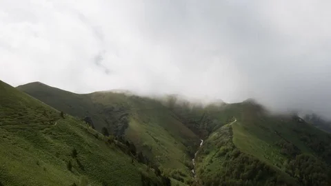 The formation and movement of clouds over the summer slopes of Bolshoy Thach Stock Footage 83493404