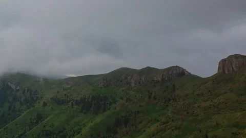 The formation and movement of clouds over the summer slopes of Bolshoy Thach Stock Footage 83493541