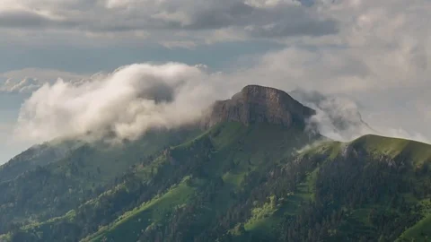 The formation and movement of clouds over the summer slopes of Bolshoy Thach Stock Footage 83493545