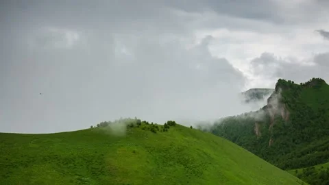 The formation and movement of clouds over the summer slopes of Mountains Stock Footage 149980644