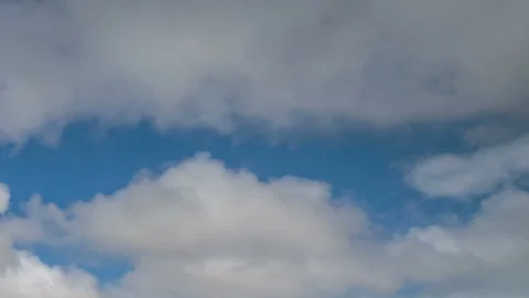 Formation and movement of white clouds of different shapes in the blue sky Stock Footage 94897418