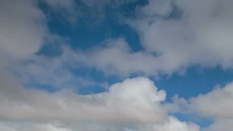 Formation and movement of white clouds of different shapes in the blue sky Stock Footage 94897432