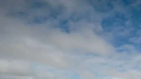Formation and movement of white clouds of different shapes in the blue sky Stock Footage 94897433