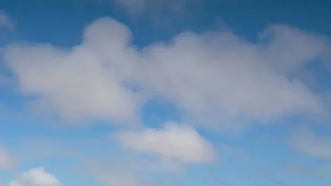 Formation and movement of white clouds of different shapes in the blue sky Stock Footage 94897435