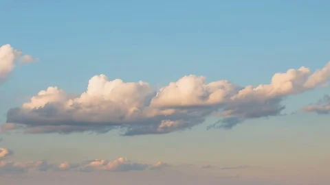 Formation and rapid movement of white clouds of different shapes at sunset Stock Footage 75965792