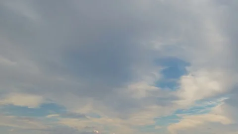 Formation and rapid movement of white clouds of different shapes in the blue sky Stock Footage 77731760