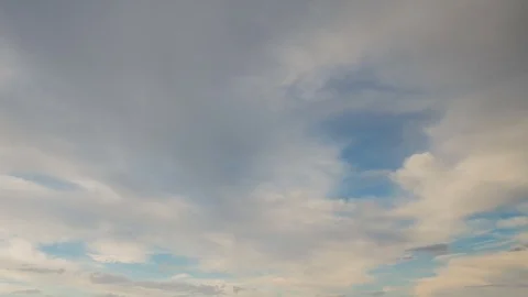 Formation and rapid movement of white clouds of different shapes in the blue sky Stock Footage 77733999