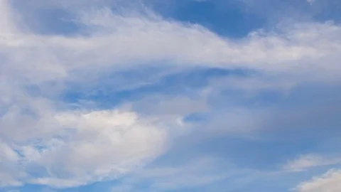 Formation and rapid movement of white clouds of different shapes in the blue sky Stock Footage 77734157