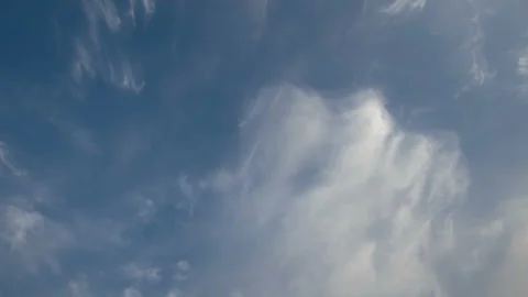 Formation and rapid movement of white clouds of different shapes in the blue sky Stock Footage 90398715