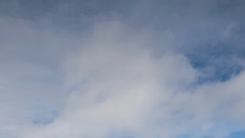 Formation and rapid movement of white clouds of different shapes in the blue sky Stock Footage 103377331