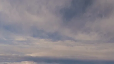 Formation and rapid movement of white clouds of different shapes in the blue sky Stock Footage 103377397
