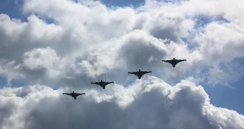 Formation of fighter jets soaring through a dramatic cloudy sky during a Stock Photos