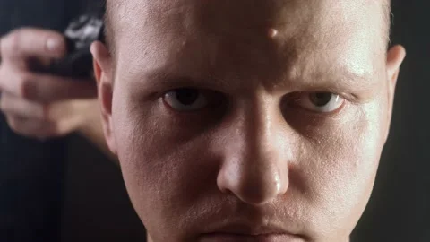 A formidable man looks. He is cut bald. Hair falls in front of the face Stock Footage 170567358