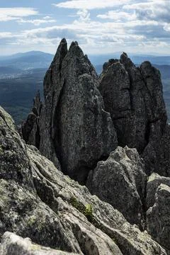 Formidable sharp gapped grey rocks on peak of mountain and panorama view on v Stock Photos