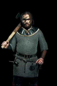Formidable viking in armor and axe on black background Stock Photos