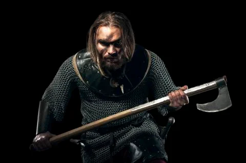 Formidable viking in armor and axe on black background Stock Photos