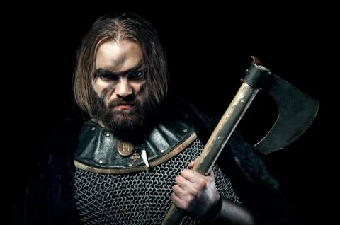 Formidable viking in armor and axe on black background Stock Photos