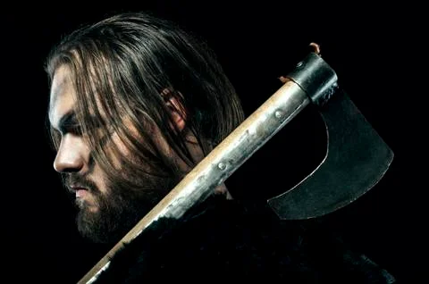 Formidable viking in armor and axe on black background Stock-Fotos