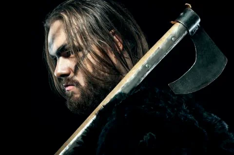 Formidable viking in armor and axe on black background Stock Photos