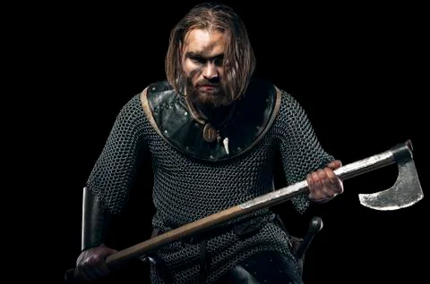 Formidable viking in armor and axe on black background Stock Photos