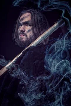 Formidable viking in chain armor over black background with smoke Stock Photos