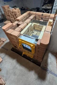 Forming the fireclay core of a solid-fuel stove. Building a heating furnace.  Fotos de archivo