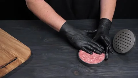 Forming hamburger beef for cooking. Chef pressing on beef to shape patty. Video stock 222617743