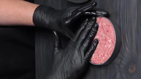 Forming hamburger beef for cooking. Chef pressing on beef to shape patty. Video stock 234009139