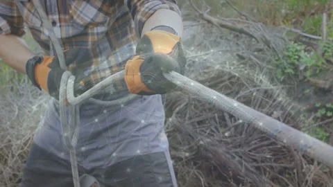 Forming loop with left hand, worker pulling speckled rope and tightening knot to Stock Footage 333526580