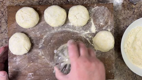 Forming a round piece of raw dough to make syrniki on a wooden cutting board. Stock Footage 301327147