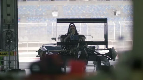 Formula one car in garage with wheels off before competition. Stock Footage 157396829