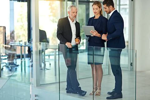 Formulating a plan of action. three colleagues talking together over a digital Stock Photos