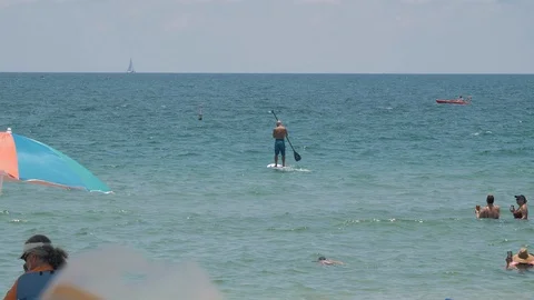 Fort laudaurdale beach,FL:man driving a paddle board at the beach Stock Footage 93649825