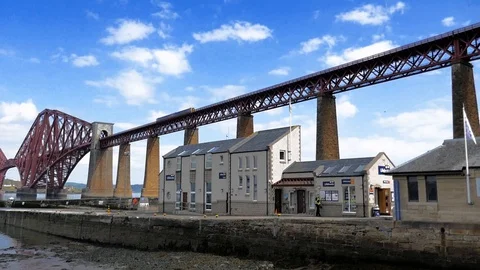 Forth bridge, while train passes by and a police man walking Stock Footage 92621032