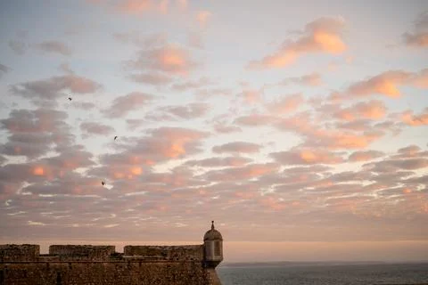 Fortress wall beneath patterned evening clouds in Peniche Foto stock