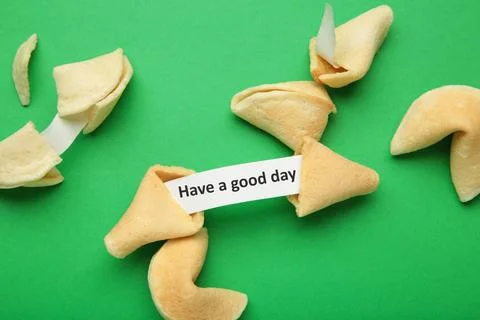 Fortune cookie with text saying 'Have a good day' on green background Stock Photos