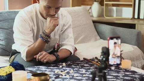 Fortune teller casting a spell and scattering shells on a table while recording Stock Footage 280227336