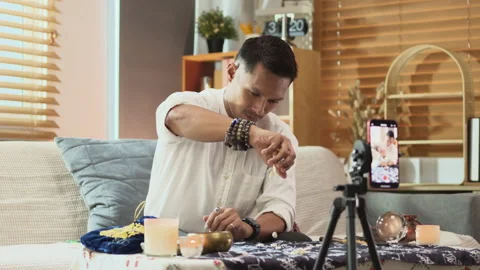 Fortune teller casting a spell and scattering shells on a table while recording Stock Footage 280228019