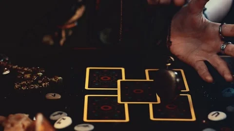 A fortune teller conjures an amulet over Tarot cards spread out on the table. Stock Footage 163711608