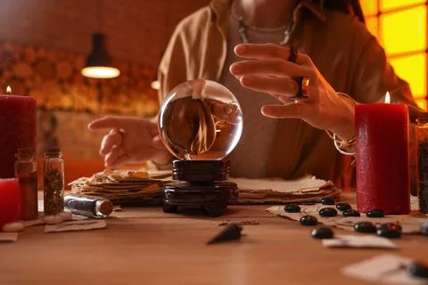 Fortune teller with crystal ball reading future  at table Stock Photos