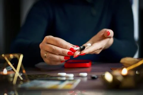 A fortune teller does online fortune telling on photos from a smartphone. Stock Photos