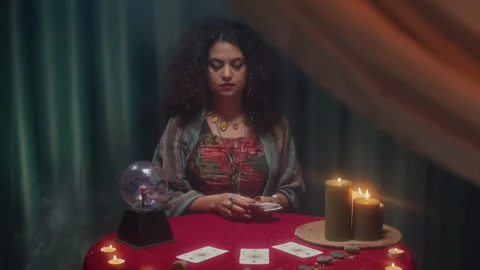 Fortune Teller Doing Tarot Cards Layout at Table with Burning Candles Stock Footage 253181020