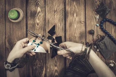 A fortune-teller or oracle cuts a photograph with large scissors. Divination  Stock Photos