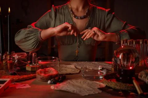 Fortune teller with pendulum reading future  at table Stock Photos