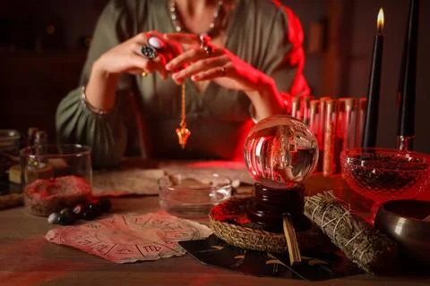 Fortune teller with pendulum reading future  at table Stock Photos