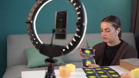 Fortune teller predicting the future and reading tarot cards at home recording a Stock Footage 252601084